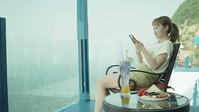 年轻女士坐在落地窗前玩手机享受下午茶时光视频的预览图